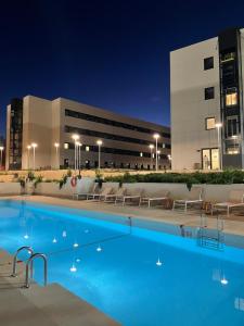 a swimming pool in front of a building at night at Stephouse Pozuelo Europa in Madrid