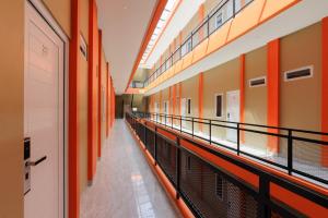 un pasillo vacío de un edificio con paredes de color naranja en RedDoorz near GSG UNILA Lampung, en Hajimana