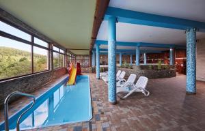 a swimming pool with lounge chairs and a swimming pool at Hotel Beskidzki Raj Medical SPA in Stryszawa