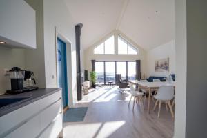 a kitchen and dining room with a table and chairs at Stylish Coastal House with Stunning Ocean View in Borhaug
