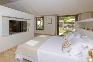 a bedroom with a white bed with a large window at Maison Belleviste in Maillane +29 photos