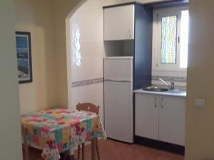 a kitchen with a table and a white refrigerator at apartamento Isleta del Moro, Cabo de Gata in La Isleta del Moro