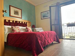 a bedroom with a bed with a red comforter at B&B Donna Sabella in Santa Flavia