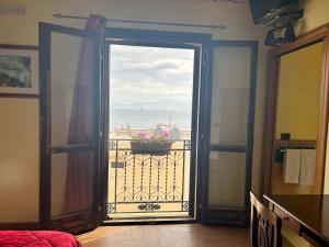 サンタ・フラーヴィアにあるB&B Donna Sabellaの海の景色を望むバルコニーに面したオープンドア