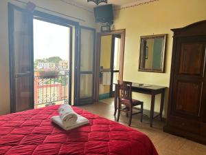a bedroom with a bed and a desk and a window at B&B Donna Sabella in Santa Flavia