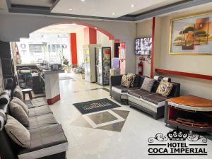 奧雷亞納弗朗西斯科港的住宿－Hotel Coca Imperial，带沙发的酒店客房和咖啡厅