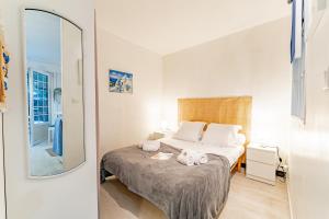 een slaapkamer met een bed en een spiegel bij Le Relax - Appt avec terrasse à 5mn de la plage in Arcachon