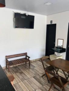 Zimmer mit 2 Bänken und einem TV an der Wand in der Unterkunft Área de lazer Simões in Assis
