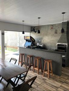 uma cozinha com um bar com cadeiras e uma mesa em Área de lazer Simões em Assis