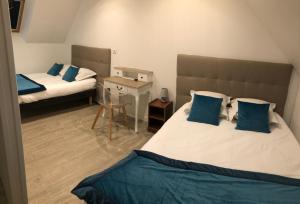 1 dormitorio con 2 camas y almohadas azules en Les gîtes de Joséphine proche Chambord en Courbouzon