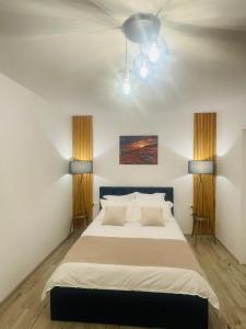 Apartament CHIC في فاترا دورني: غرفة نوم بسرير كبير فيها مصباحين