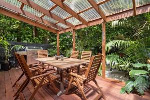 a wooden table and chairs on a wooden deck at Charming 3 Bedroom Artist House in Mosman in Sydney
