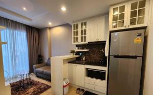a kitchen with a refrigerator and a living room at The patio บางแสน F5 R58 in Ban Bang Saen (1)