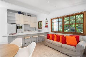 sala de estar con sofá y almohadas de color naranja en Charming 3 Bedroom Artist House in Mosman, en Sídney