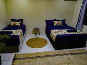 a room with two beds and a table in it at Yaubula Accommodation 2 in Nadi