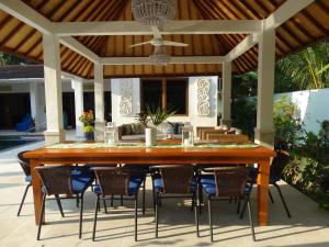 a wooden table and chairs under a pavilion at Villa Serenity in Candidasa