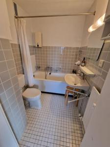 a bathroom with a toilet and a sink and a tub at River View Apartment in Hamburg