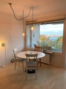 a dining room with a table and chairs and a window at River View Apartment in Hamburg