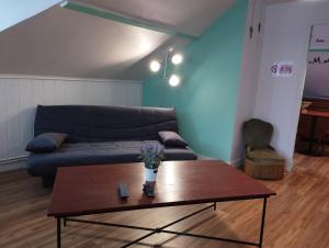 sala de estar con sofá y mesa de centro en L'Hirondelle, en Le Tréport