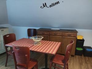 een keuken met een tafel en stoelen en een kast bij L'Hirondelle in Le Tréport