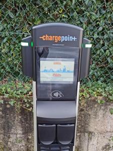 a charge point machine sitting in front of a fence at Kyriad Quimper - Pont-l'Abbé in Pont-lʼAbbé