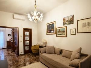 Una sala de estar con un sofá y una lámpara de araña. en Central Apartment Ca' dei Ferro - MURANO Venice, en Murano
