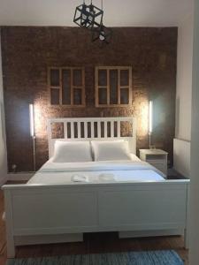 un letto bianco in una camera da letto con muro di mattoni di Merkezi Konforlu ve Şık Daire a Istanbul