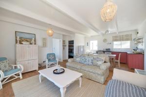 una sala de estar con un sofá y una mesa en Chez Nous In Arniston, en Arniston 21 fotos más