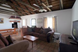 a living room with a couch and a tv at Blou Branders Kassiesbaai Arniston in Arniston