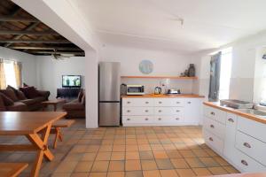 a kitchen and living room with a table and a couch at Blou Branders Kassiesbaai Arniston in Arniston