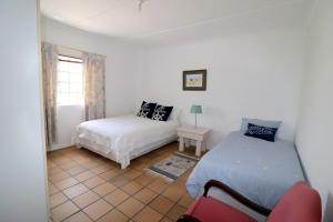 a bedroom with two beds and a window at Blou Branders Kassiesbaai Arniston in Arniston