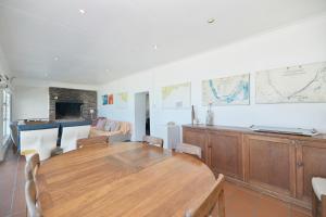 sala de estar con mesa de madera y sofá en Cliff Cottage In Arniston, en Arniston