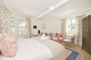 sypialnia z dużym białym łóżkiem i krzesłem w obiekcie Cliff Cottage In Arniston w mieście Arniston