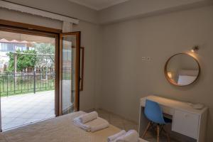 a bedroom with a bed and a desk and a mirror at Coral Apartments in Parga