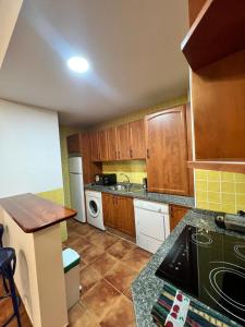 a kitchen with wooden cabinets and a white appliance at Torremolinos Plaza Del Ayuntamiento Sun&Beach in Torremolinos