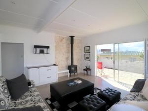 a living room with a couch and a stove at Eland's Rest In Arniston in Arniston