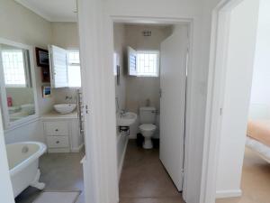 a bathroom with a tub and a toilet and a sink at Eland's Rest In Arniston in Arniston