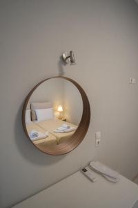 a mirror on a wall with a bed in a room at Coral Apartments in Parga