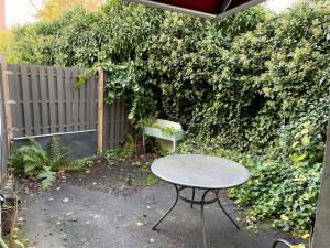 a table and a bench in front of a fence at Nice Apartment in Brühl in Brühl