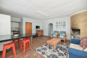 cocina y sala de estar con mesa y sillas en Etna Flat In Arniston en Waenhuiskrans