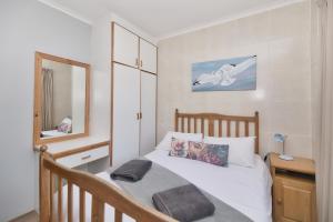 1 dormitorio con cama blanca y espejo en Etna Flat In Arniston en Waenhuiskrans