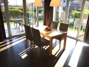 a dining room with a wooden table and chairs at Mueritz-Ferienhaus-Wiesenblick-|-Garten-Sauna-Kamin-und-Boot-|-200-Meter-zur-Mueritz in Marienfelde +6 photos