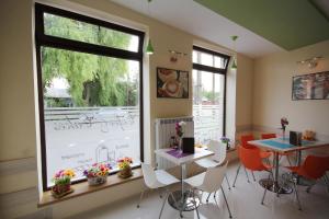 a room with a table and chairs and a large window at Pensiunea President City in Roşiori de Vede