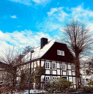 a black and white house with a snow covered roof at Ferien Fachwerkhaus in Olsberg