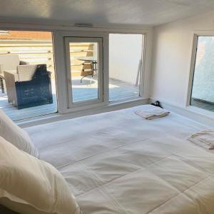 uma grande cama branca num quarto com janelas em NEW TOP DUPLEX CENTRE AVEC TERRASSE ET PARKING em Clermont-Ferrand