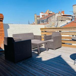 a patio with two chairs and a bench on a deck at NEW TOP DUPLEX CENTRE AVEC TERRASSE ET PARKING in Clermont-Ferrand