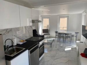 a kitchen with a sink and a table in a room at NEW TOP DUPLEX CENTRE AVEC TERRASSE ET PARKING in Clermont-Ferrand