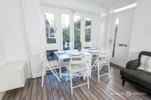 uma sala de jantar com uma mesa branca e cadeiras em Tranquil 3-Bedroom Haven in Lymington - The Herons Nest em Lymington