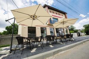 a group of tables and chairs with umbrellas at Pensiunea President City in Roşiori de Vede