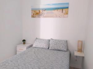 een slaapkamer met een bed en een schilderij van een strand bij Casa Belice in Vila Real de Santo António